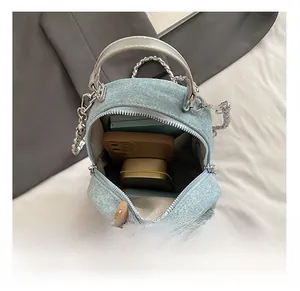 Internal view of denim mini backpack showing storage capacity for phone and cosmetics
