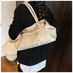 Detail einer beigen Plissee-Ledertasche mit Goldschnalle und verstellbarem Schultergurt