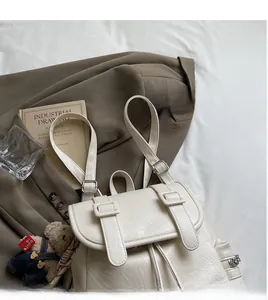 Détail du sac à dos en similicuir plissé crème avec boucles et fermeture éclair latérale