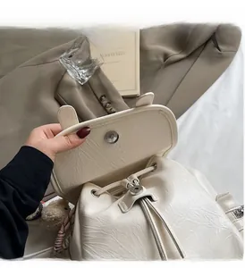 Détail de la boucle magnétique et du cordon sur le sac à dos en cuir crème