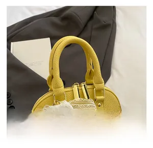 Detail show of yellow shell bag with lychee grain leather, lace scarf and pearl pendant