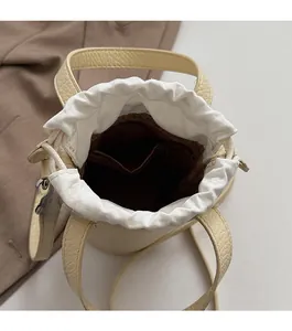 Vue de dessus du sac seau beige montrant la fermeture à cordon et la poche zippée interne