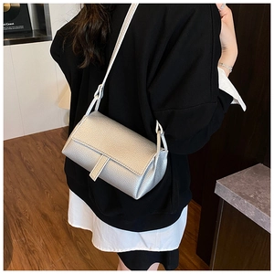 Detail of silver lychee texture faux leather crossbody bag with a modern flap design