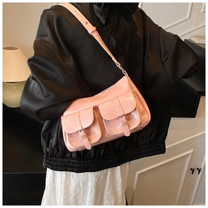 Detailed view of pink patent leather tote bag featuring dual pockets and silver buckles