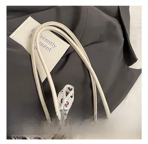 Detail of beige PU leather handle with black-white plaid scarf and lace heart ribbon