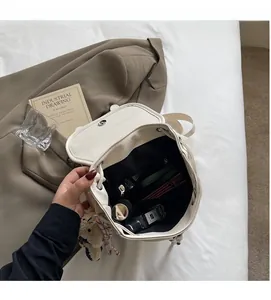 Vue intérieure du grand sac cabas en cuir beige avec poches et breloque ours