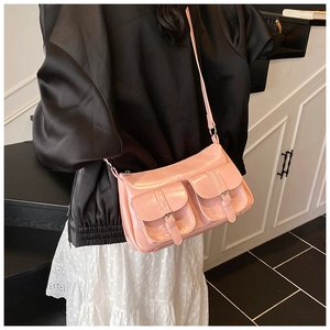 Detailed shot of pink shiny faux leather crossbody bag with double buckle front pockets