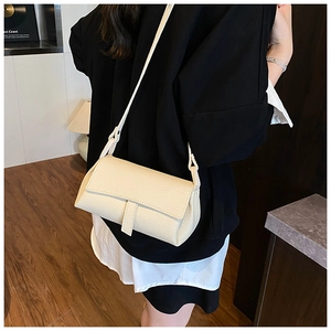 Detail of cream white lychee leather crossbody bag with minimalist rectangular flap design