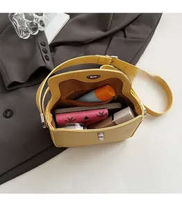 Vue intérieure d'un sac bandoulière en cuir jaune montrant le rangement et la poche zippée