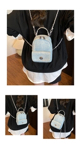 Detail of light blue denim mini backpack showing silver chain and metallic handle