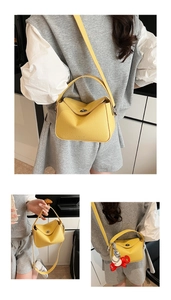 Détails du sac à main en cuir grainé jaune avec fermoir argenté et breloque éléphant rouge