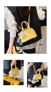 Detail of yellow shell bag featuring large lace bow and pearl heart pendant