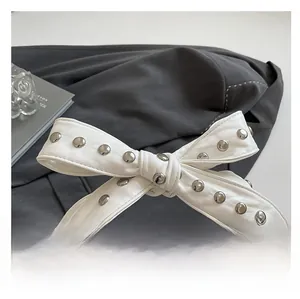 Détail du sac en cuir blanc avec large bandoulière à nœud riveté et zip métallique