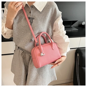 Pink lychee texture crossbody bag with silver whale pendant detail on model