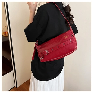 Close-up of deep red glossy patent leather shoulder bag with metallic buckle detail