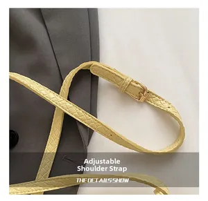 Gros plan sur la bandoulière réglable tissée jaune clair avec boucle en métal doré