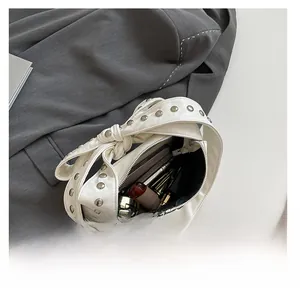 Détail de la capacité intérieure du sac blanc montrant téléphone et maquillage