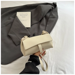 Macro view showing the lychee pattern leather texture and finish of the beige pillow bag