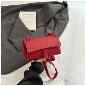 Detail of red lychee textured leather crossbody bag with white contrast stitching