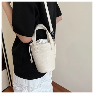 Detail of white lychee pattern leather bucket bag with silver hardware and drawstring