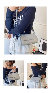 Detail of light gray woven shoulder bag featuring premium texture and intricate weave