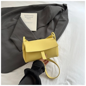 Detailed view of yellow lychee texture leather handbag on stylish minimal background