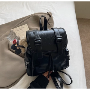 Détail du sac à dos noir en cuir PU plissé avec cordon et breloque ours en peluche
