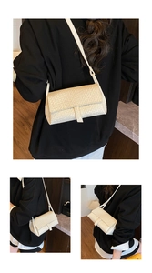 Detail view of a beige woven texture shoulder bag with adjustable strap and flap closure