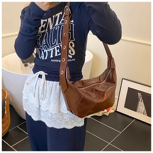 Détails de sac besace marron en similicuir avec texture plissée et œillets métalliques