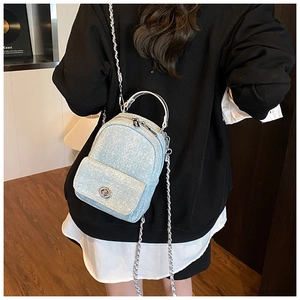 Detail of light blue glitter backpack with silver chain strap and metallic lock closure