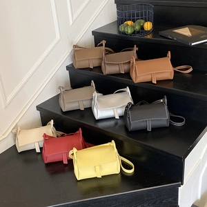 Minimalist crossbody pillow bag set in nine colors displayed on stairs