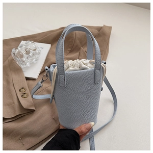 Gros plan du sac seau bleu clair motif lychee avec doublure à cordon blanc et détails argentés