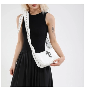Détail du sac bandoulière gothique en cuir verni blanc avec croix argentée et œillets
