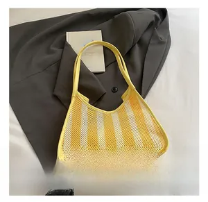 Detail of yellow striped mesh tote bag placed on dark grey suit in a lifestyle setting