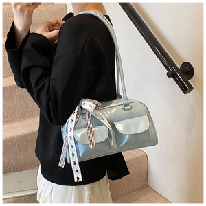 Close-up of light blue patent leather underarm bag with double front pockets and silk scarf