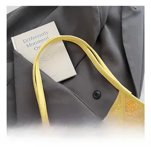 Detail of comfortable yellow handle on a mesh patchwork hobo bag with neat stitching