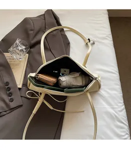 Internal view of beige baguette bag showing capacity for phone and daily items