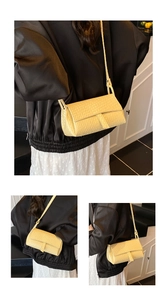 Detail of light yellow woven crossbody bag featuring premium faux leather texture and flap closure