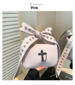 Pink bow handbag featuring silver studs and metallic cross charm in a stylish setting