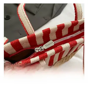 Detailansicht des hochwertigen Metallreißverschlusses einer rot-weiß gestreiften Tasche