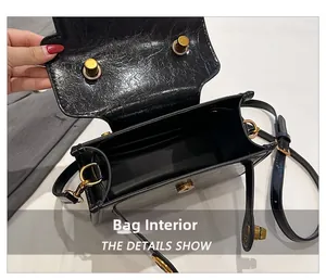 Dettaglio dell'interno della borsa in pelle verniciata nera con fibbia in metallo oro