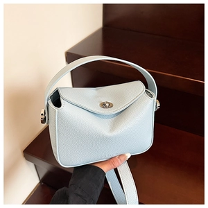 Détail du sac Lindy bleu clair en cuir grainé avec fermoir rotatif en métal argenté brillant