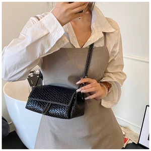 Close-up of black woven leather texture on a minimalist crossbody bag for women