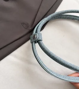 Detail of premium charcoal gray metal buckle on denim shoulder bag with reinforced stitching
