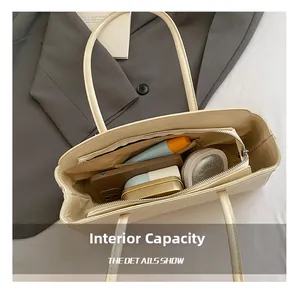 Capacité interne du sac fourre-tout crème montrant le rangement du maquillage