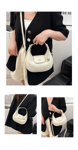 Dettagli della borsa hobo bianca con texture pelle martellata e ciondolo a cuore