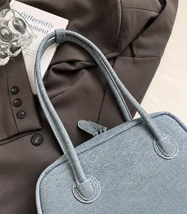 Close-up of comfortable denim Boston bag shoulder straps with reinforced stitching detail