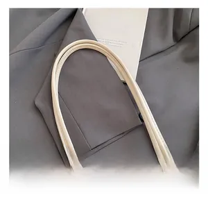 Vue détaillée de la poignée arrondie et du cuir crème sur le sac à main rétro