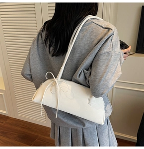 Detail of white litchi pattern underarm bag featuring a stylish bow knot strap design