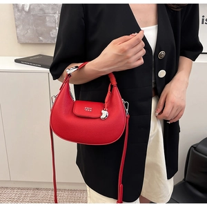 Dettaglio della borsa a mezzaluna rossa in pelle litchi con finiture in argento